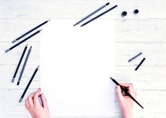 Mock up for calligraphy.  Hands holding the empty white paper sheet, and a calligraphy pen. A few...