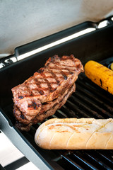 Rumpsteaks, Baguette und Mais am Grill