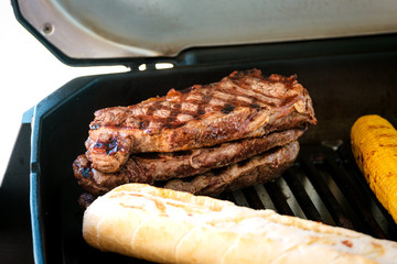 Rumpsteaks, Baguette und Mais am Grill