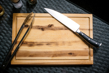 Holzbrett, Messer und Grillzange