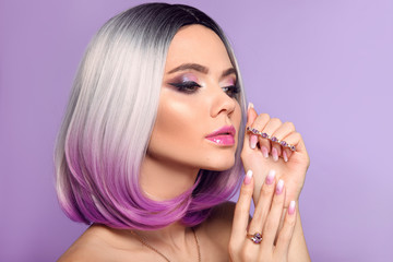 Ombre bob short hairstyle. Woman portrait with blond purple hair and manicured nails. Beauty makeup. Beautiful girl model isolated on violet background. © Victoria Andreas