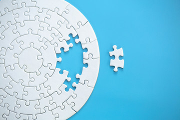 White jigsaw puzzle pieces on a blue background. Problem solving concepts. Texture photo with copy space for text - obrazy, fototapety, plakaty