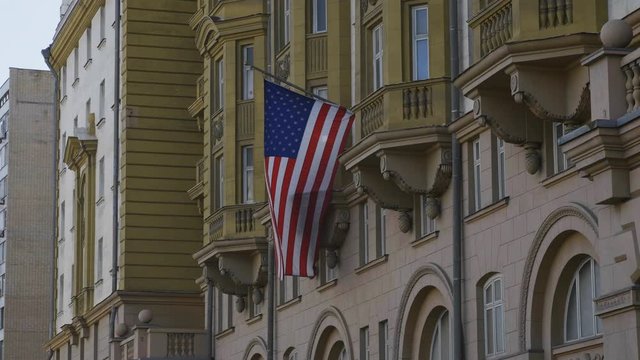 Wrapped around flagpole flag of the USA in Russia Moscow.