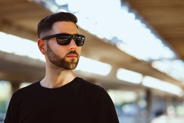 Portrait of a short bearded man wearing black sunglasses