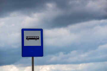 Bus stop street sign post close up shot on a cloudy , overcasted day. 