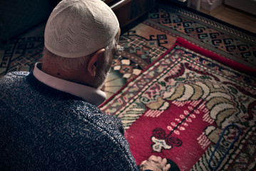 Very old Turkish muslim man doing Salah prayer at his home on his prayer rug