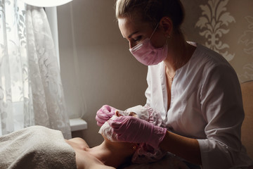Obraz na płótnie Canvas Woman is getting facial mask at spa salon
