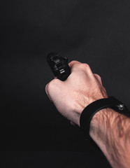 Male hand with gun isolated on black background. Man with a gun ready to shoot, focus on the weapon.
