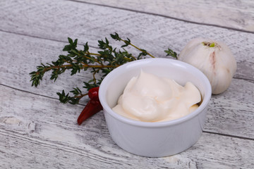 Mayonnaise sauce in the white bowl served thyme and garlic