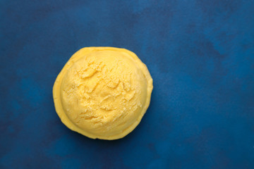 Ice-cream scoop on blue background, copy space. Summer vacation, refreshment, traditional seasonal cold sweets
