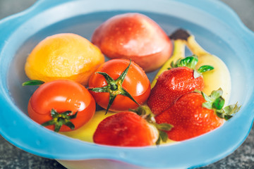 Basin with different fruits filled with water with bleach to disinfect the fruit and prevent the spread of the coronavirus.
