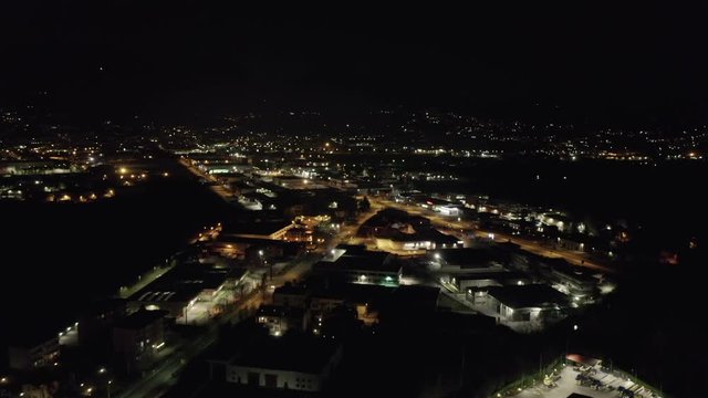 Aerial view of industrial area at night, with view on industry, highway and downtown