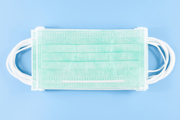 Medical surgical face mask for coronavirus disease (COVID-19) prevention on blue background