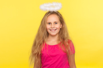 Portrait of beautiful happy little girl with long fair hair and angelic halo looking at camera with...