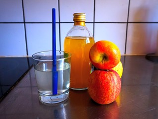 a glass of bottle of raw apple cider vinegar or apple juice