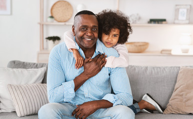 Bond between grandparents and grandchildren. Cute girl with her loving grandpa at home