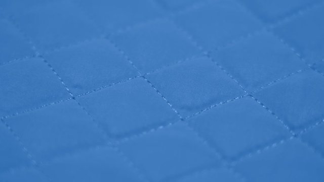 Closeup view video of blue quilted texture of fabric.