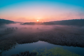 Fototapeta na wymiar Early misty morning. Sunrise over countryside. Rural landscape in early spring. Aerial view
