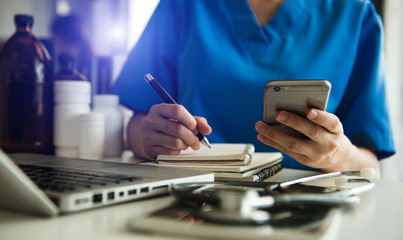 Medical technology concept. Doctor working with mobile phone and stethoscope and digital tablet laptop in modern office at hospital 

