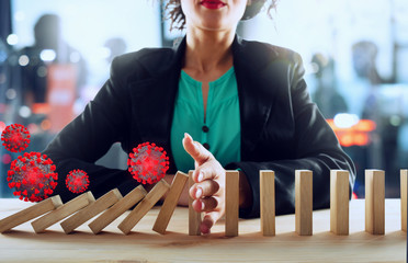 Businesswoman stops a chain fall by viruses like domino game. Concept of preventing crisis and...