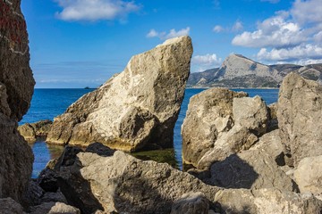 Rocky coast of Black Sea. Cape Alchak. Wildlife near ancient city built by Genoese. Velvet season in Sudak in Crimea. Huge stones and boulders in sea and on background of sea. Close-up.