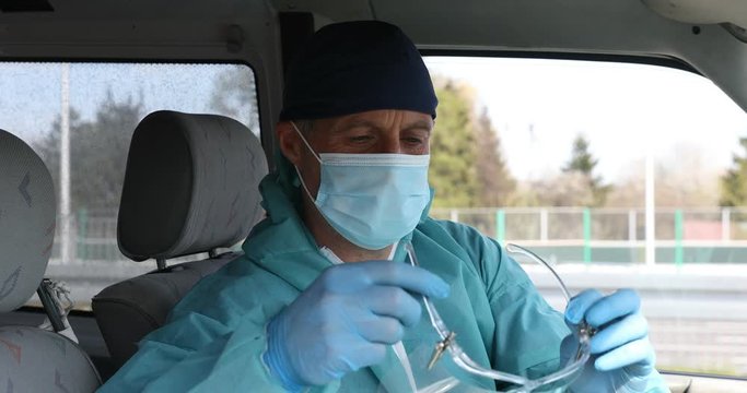 Ambulance Medical Driver Wears A Medical Mask. Driver Wearing An Anti-virus Mask Protecting Others Against COVID-19 And SARS Cov 2 Crown Infection