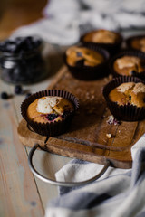 vanilla muffins with black currants on a wooden plate