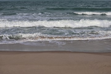 Small surf breaking on smooth sand
