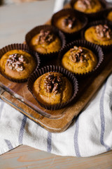 pumpkin muffins with nuts on a wooden plate