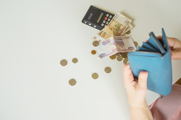 close-up of an elderly woman's hand counting coins Russian rubles on the background of a first-aid kit with medicines on a white table background place for text