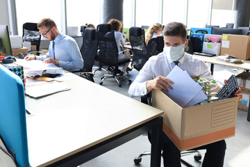 Dismissal employee in preventive medical mask in an epidemic coronavirus. Sad dismissed worker are...