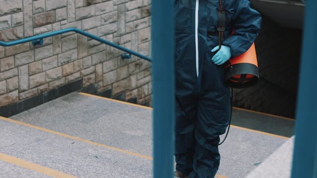African man with protective suit disinfecting the streets. Prevention of the coronavirus spread