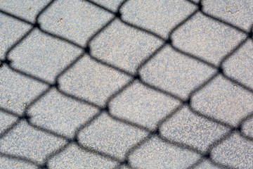 Wire fence shadow on floor
