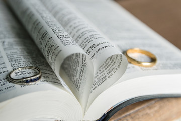 Alliances sur une bible avec un coeur formé par deux pages