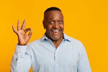 Happy middle aged african american man gesturing okay sign