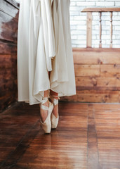 Fototapeta na wymiar Strong professional ballet dancer feet standing on toes in studio close up. Vertical frame.