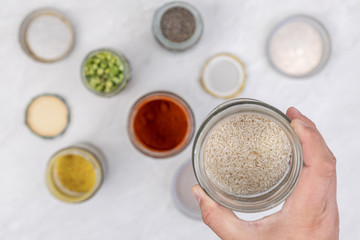 Rice in the jar above spices in the jars on the kitchen table. Home kitchen concept with groceries in the jars