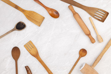 Top view of kitchen wooden utensils on the grey marble kitchen table top with copy space. Food concept with kitchen utensils on the grey background with copyspace