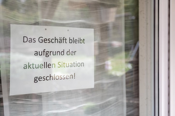 Hinweisschild am Fenster eines Geschäftes mit dem Satz 
