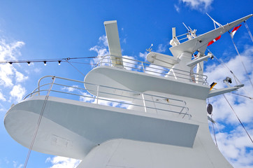 White mast of modern cruise ship or cruiseship liner against blue sky