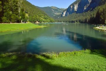 Fototapeta premium Lake of Montriond, natural lake in Portes du Soleil, Haute -Savoie region, France, an attraction for many tourists, with swimming area, fishing, canoeing.