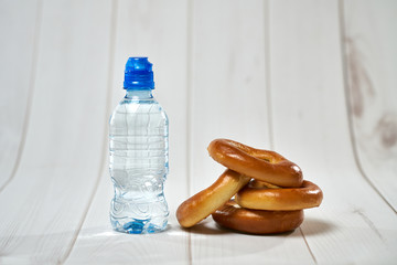 A bottle of water, crackers, drying on the background of boards for a healthy lifestyle.