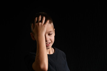 young boy in a black t-shirt on a black background