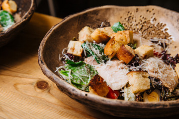Salad of chicken breast slices, green salad, Parmesan cheese and croutons.