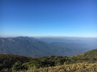 The scenic view from Nishani Betta Peak, Coorg, India. Blue sky, great mountains and valleys.