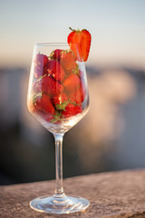 Strawberries in a wine glass on a blurry background. Fresh strawberry close-up.