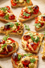 Hot crust toasts with ham, olives, tomatoes and cheese, breakfast idea.