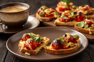 Hot crust toasts with ham, olives, tomatoes and cheese, breakfast idea.