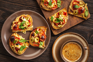Hot crust toasts with ham, olives, tomatoes and cheese, breakfast idea.