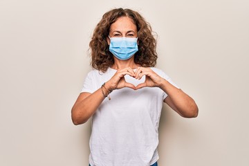 Middle age woman wearing coronavirus protection mask for covid-19 epidemic virus smiling in love...